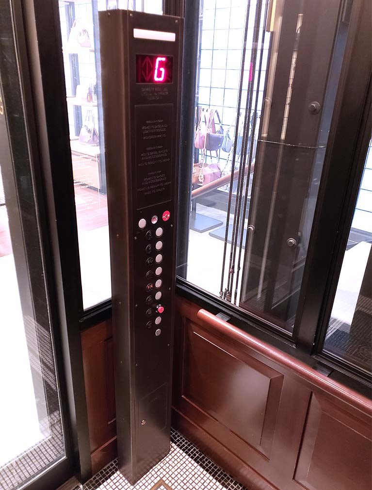 Coach held to brand standards in their pillar designed elevator call buttons