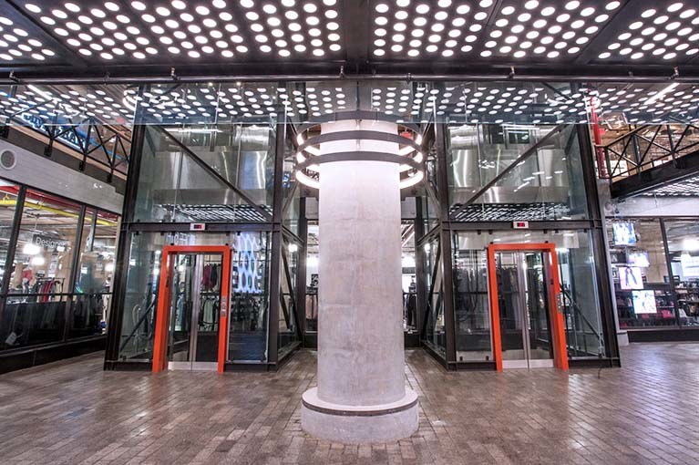850 Third Ave, Brooklyn, double elevator bay,straight on lobby, glass elevators with black steel girders & orange accent door frames