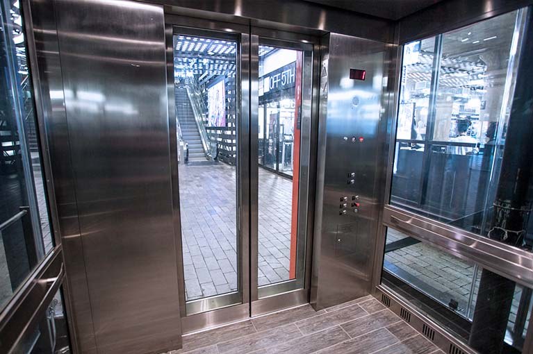 850 Third Ave, Brooklyn, glass elevator cab interior with stainless steel & glass panels