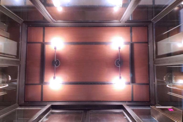 Coach used Edison style bulbs and classic light fixtures to reflect their brand elements into this elevator